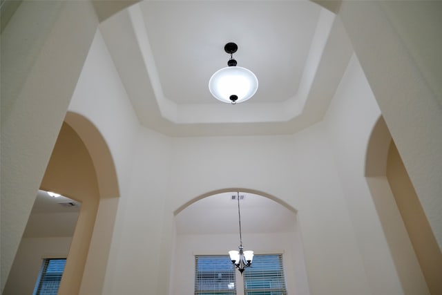 details with a chandelier and a tray ceiling