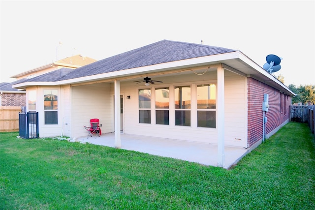 rear view of property featuring a patio, ceiling fan, and a yard