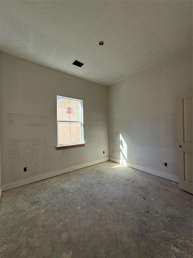 unfurnished room featuring concrete floors