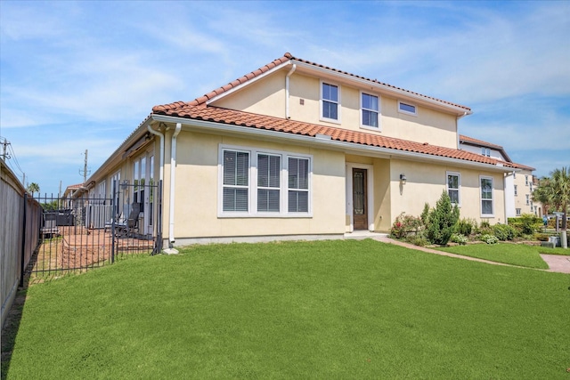 rear view of property featuring a lawn