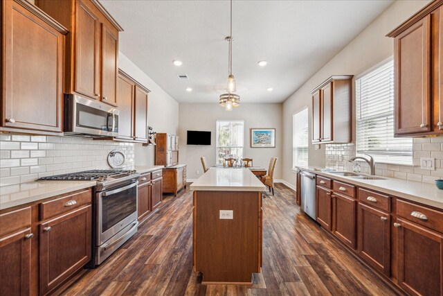 kitchen featuring a center island, sink, dark hardwood / wood-style floors, a wealth of natural light, and appliances with stainless steel finishes