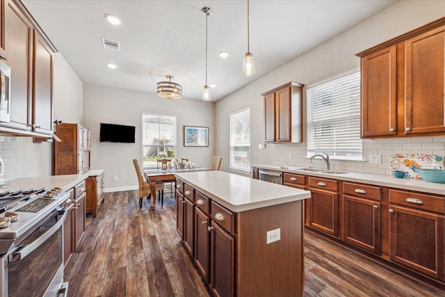 kitchen with sink, a center island, tasteful backsplash, dark hardwood / wood-style floors, and decorative light fixtures