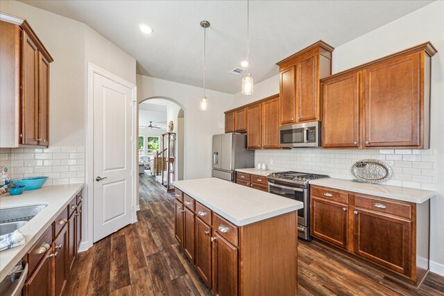 kitchen featuring pendant lighting, a center island, dark hardwood / wood-style floors, decorative backsplash, and appliances with stainless steel finishes