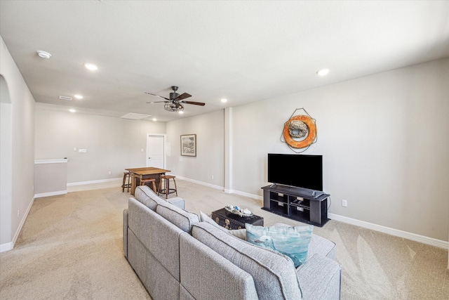 carpeted living room with ceiling fan