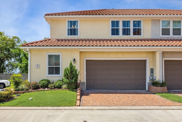 mediterranean / spanish house with a front lawn and a garage