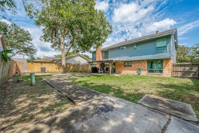 rear view of house featuring a lawn and a patio area