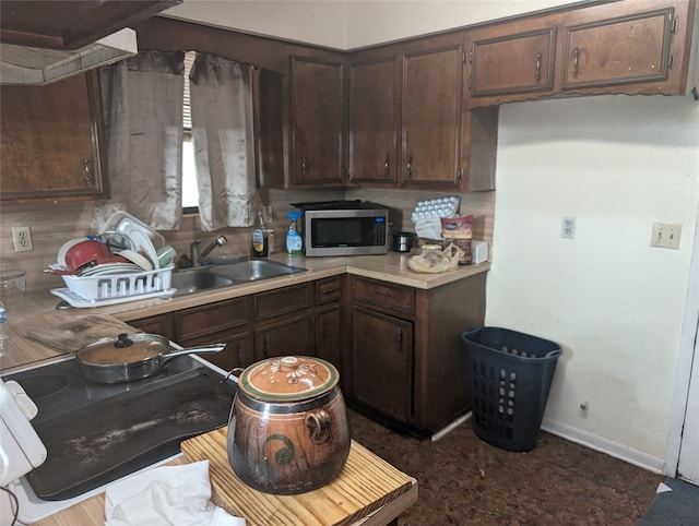 kitchen featuring sink and dark brown cabinets