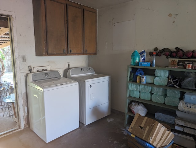 laundry room featuring washer and clothes dryer and cabinets