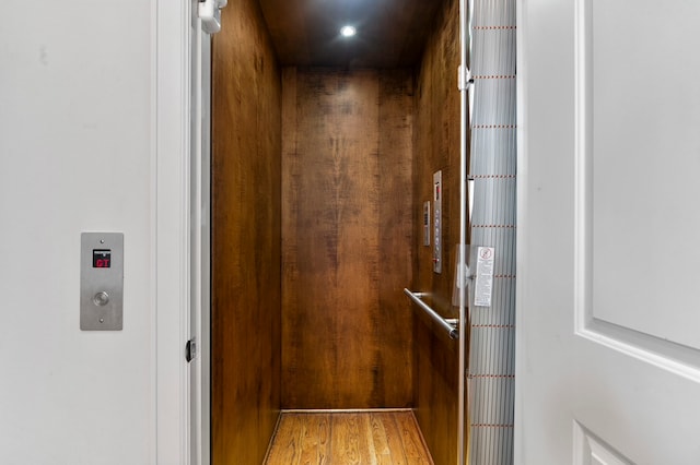 details featuring elevator and hardwood / wood-style floors