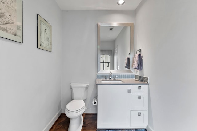 bathroom with hardwood / wood-style floors, vanity, toilet, and decorative backsplash