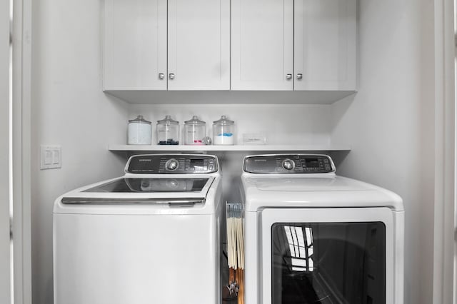 laundry area with washing machine and dryer and cabinets