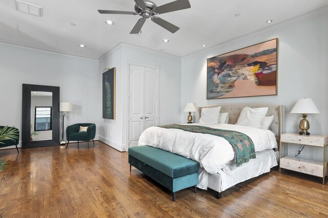 bedroom featuring ornamental molding, a closet, hardwood / wood-style floors, and ceiling fan