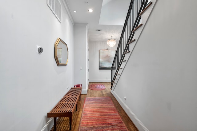 hall featuring hardwood / wood-style floors and an inviting chandelier