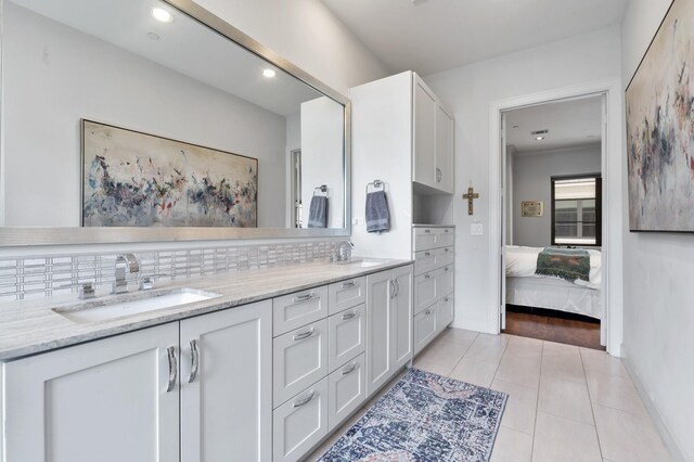 bathroom with tile patterned flooring, vanity, and backsplash