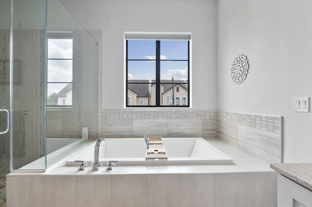 bathroom with vanity, a healthy amount of sunlight, and separate shower and tub