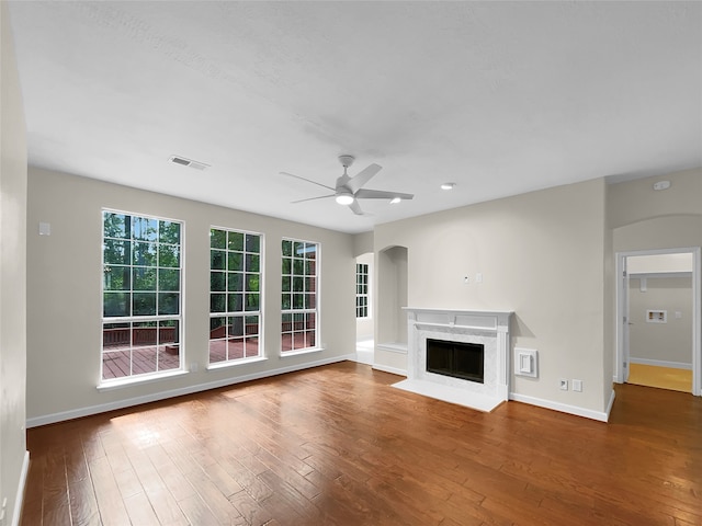 unfurnished living room featuring hardwood / wood-style floors, a high end fireplace, and ceiling fan