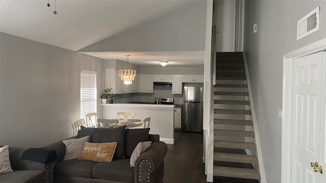 living room featuring high vaulted ceiling, dark hardwood / wood-style flooring, and a textured ceiling