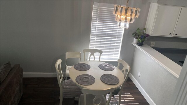 dining room with dark hardwood / wood-style flooring and an inviting chandelier