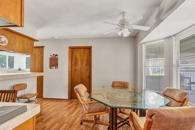 dining space with ceiling fan, light hardwood / wood-style floors, and a textured ceiling