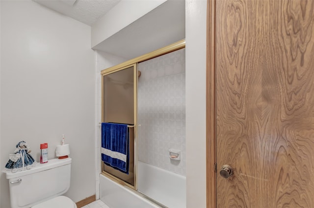 bathroom with toilet and bath / shower combo with glass door