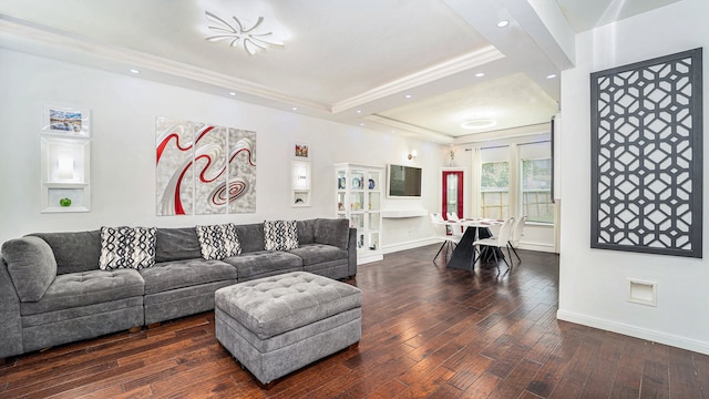 living room with crown molding, a tray ceiling, and dark hardwood / wood-style flooring