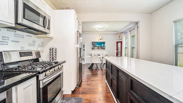 kitchen featuring light stone countertops, stainless steel appliances, dark hardwood / wood-style flooring, and white cabinetry