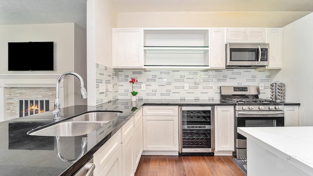 kitchen featuring appliances with stainless steel finishes, dark hardwood / wood-style flooring, wine cooler, and white cabinets