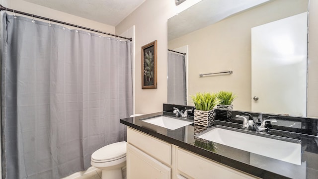 bathroom featuring a textured ceiling, vanity, toilet, and a shower with shower curtain