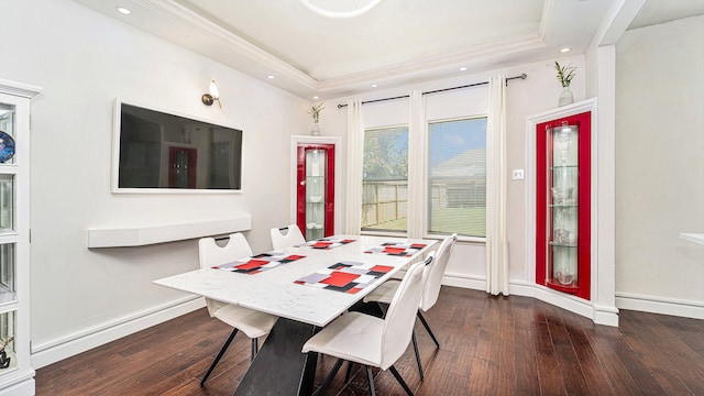 dining area with crown molding, a raised ceiling, and dark hardwood / wood-style flooring