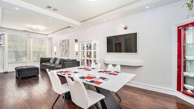 dining room featuring crown molding, dark wood-type flooring, and a tray ceiling