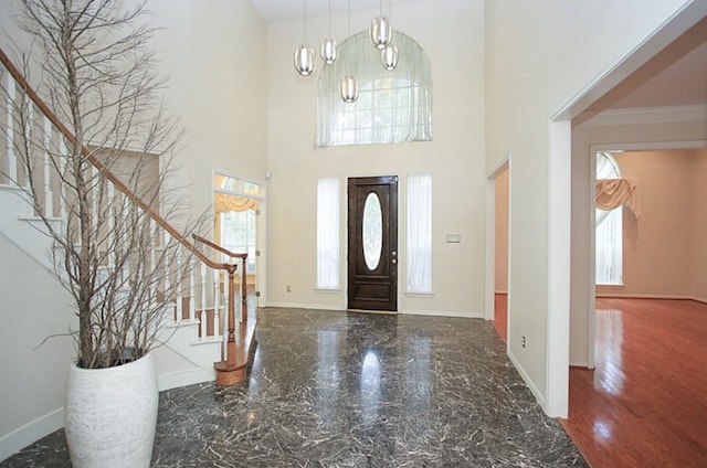 foyer entrance featuring a chandelier, hardwood / wood-style flooring, and crown molding