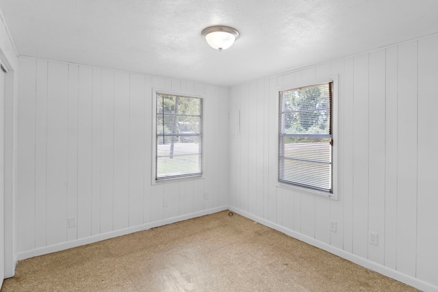 empty room featuring a textured ceiling and baseboards