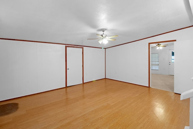 spare room with light wood-type flooring, a ceiling fan, and crown molding