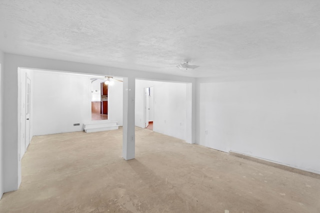 basement with a textured ceiling and a ceiling fan