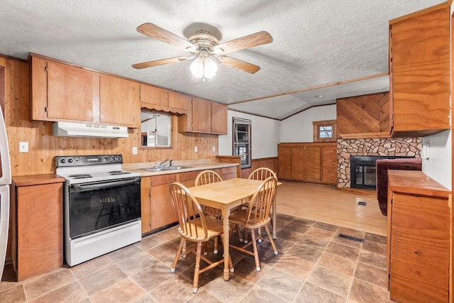 kitchen with range with electric cooktop, wainscoting, light countertops, under cabinet range hood, and a sink