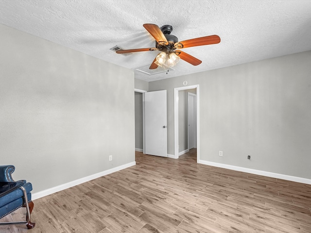 interior space with a textured ceiling, ceiling fan, and wood-type flooring