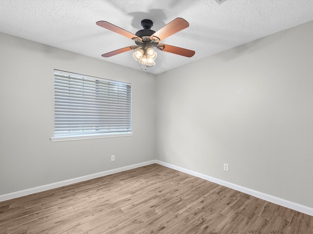 empty room with ceiling fan, hardwood / wood-style flooring, and a textured ceiling