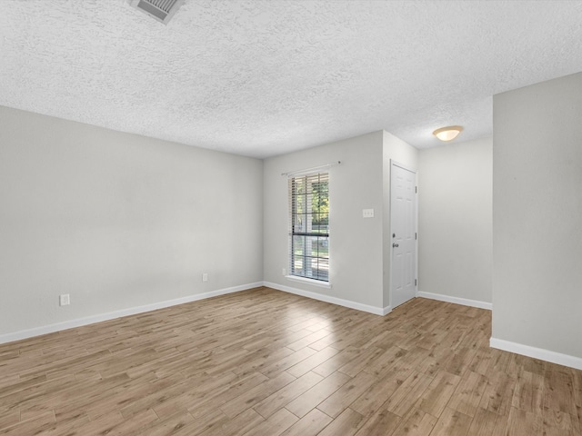 unfurnished room featuring light wood-type flooring and a textured ceiling