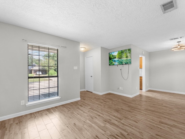 empty room featuring light hardwood / wood-style floors and a textured ceiling