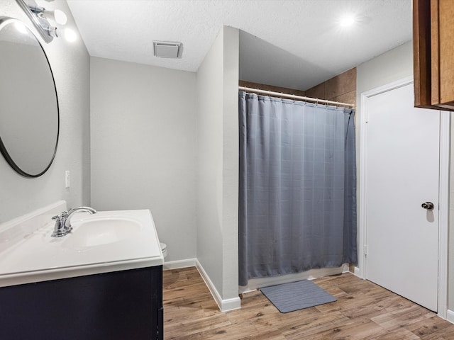 bathroom featuring a textured ceiling, hardwood / wood-style flooring, vanity, and curtained shower