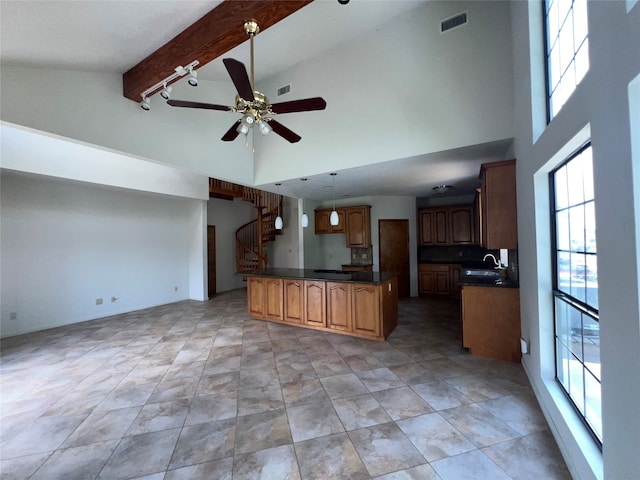 kitchen with beam ceiling, high vaulted ceiling, light tile patterned floors, a center island, and ceiling fan