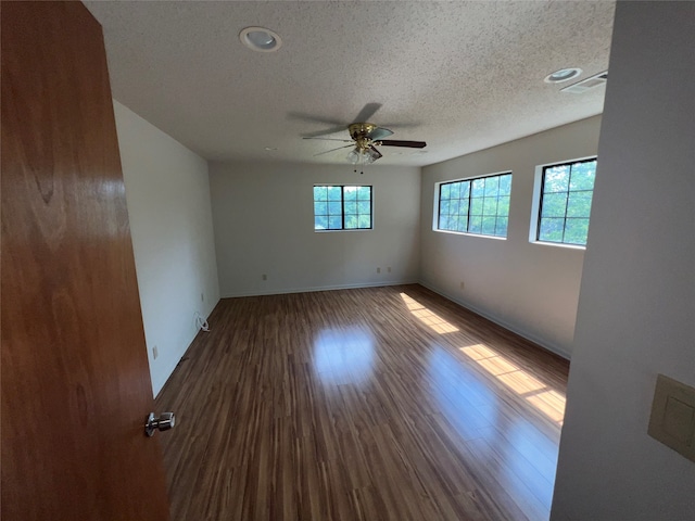 unfurnished room featuring ceiling fan, a healthy amount of sunlight, and wood-type flooring