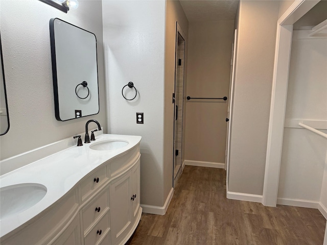 bathroom featuring vanity, hardwood / wood-style flooring, and a shower with shower door