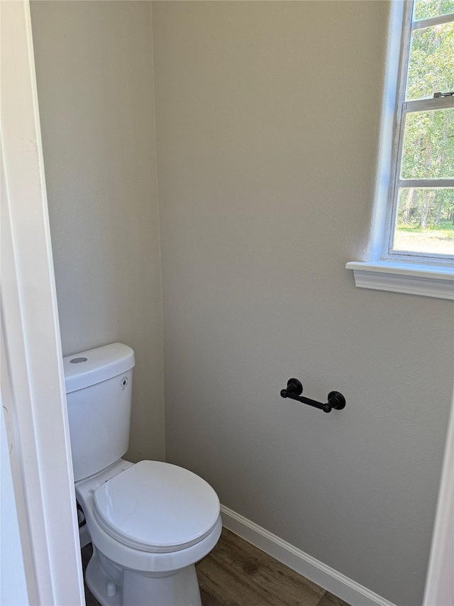 bathroom with hardwood / wood-style flooring, toilet, and a wealth of natural light