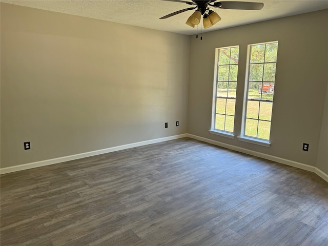 unfurnished room featuring dark hardwood / wood-style floors, ceiling fan, a textured ceiling, and a wealth of natural light