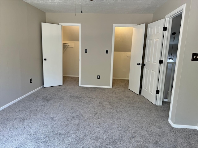 unfurnished bedroom featuring carpet flooring, a walk in closet, and a closet