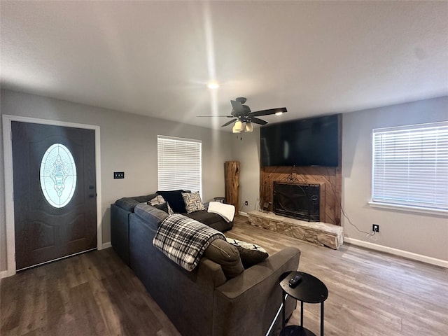 living room with ceiling fan, dark hardwood / wood-style flooring, and a fireplace