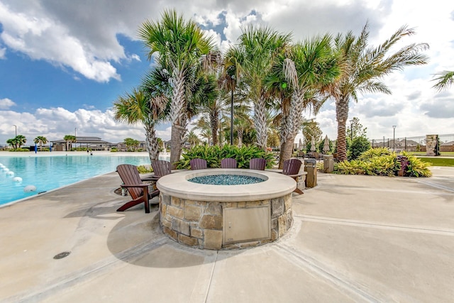 view of swimming pool with a patio and an outdoor fire pit