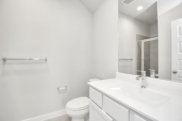 bathroom featuring vanity, toilet, and a shower with shower door