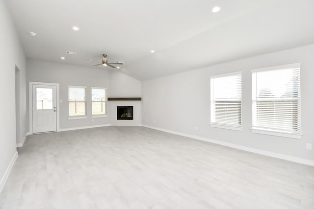 unfurnished living room featuring ceiling fan, light hardwood / wood-style flooring, and vaulted ceiling